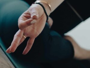 אישה מתרגלת יוגה בישיבה על מחצלת עם תרגול מדיטציה.
